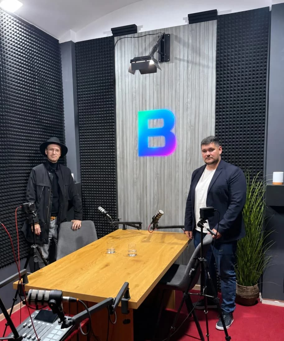 Dva muži v nahrávacím studiu u stolu s mikrofony a logem Betnito.